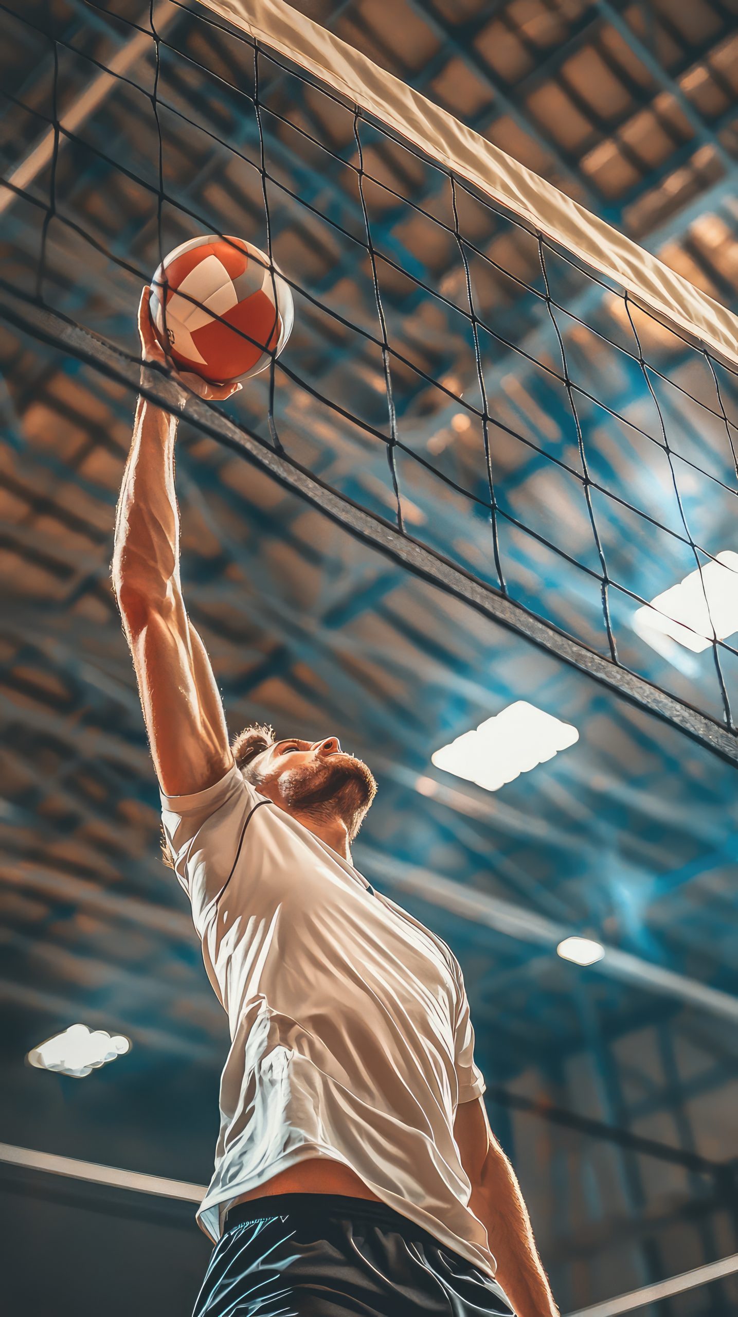 A volleyball player is spiking ball over net with great intensity and focus, showcasing athleticism and skill in dynamic indoor setting.